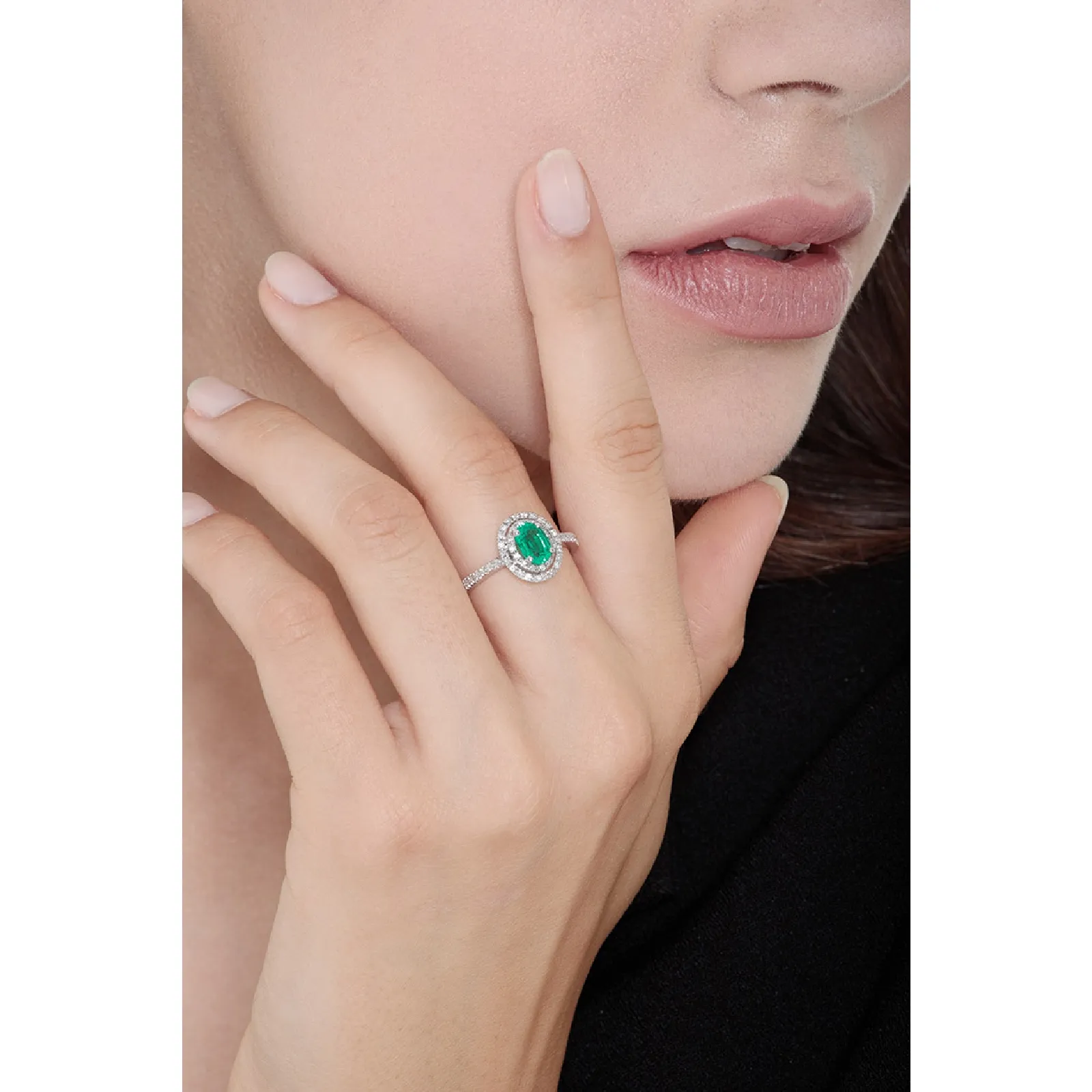 Anello in oro bianco 18k con smeraldo ovale al centro e diamanti.